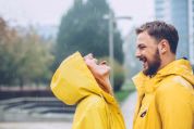 Päarchen in gelben Öljacken hat Spass im Regen Päarchen in gelben Öljacken hat Spass im Regen